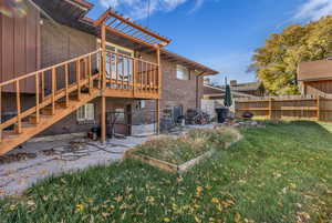 Rear view of house featuring a patio, stairway, a wooden deck, and brick siding