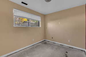 Empty room with baseboards and concrete flooring