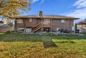 Back of house featuring brick siding, stairway, a deck, and a chimney