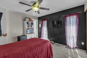 Carpeted bedroom featuring ceiling fan