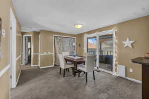 Carpeted dining room with baseboards