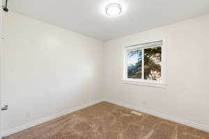 Carpeted spare room with baseboards