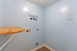 Washroom featuring hookup for a washing machine, wood finished floors, and electric dryer hookup