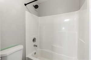 Full bathroom featuring shower / bath combination and toilet