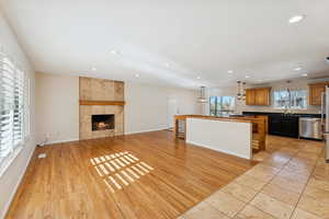 Unfurnished living room with light wood-type flooring, recessed lighting, and a tile fireplace