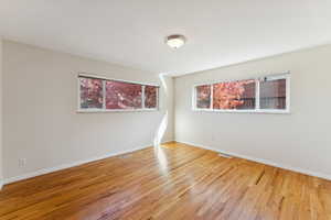 Spare room featuring light wood-style flooring and plenty of natural light