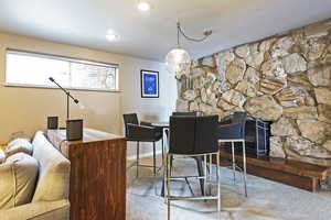 Carpeted dining room with a fireplace and baseboards