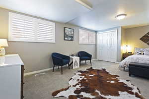 Bedroom featuring light colored carpet and a closet