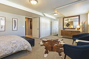 Carpeted bedroom with multiple closets and baseboards