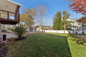 Fenced backyard featuring a storage shed
