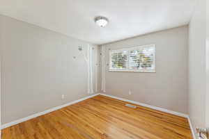 Unfurnished room with wood finished floors and baseboards