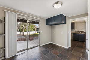 Kitchen with stone tile floors, light countertops, and dark cabinetry