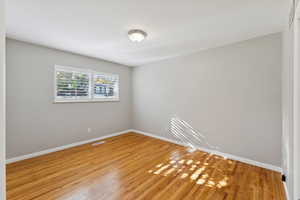 Unfurnished room featuring baseboards and wood finished floors
