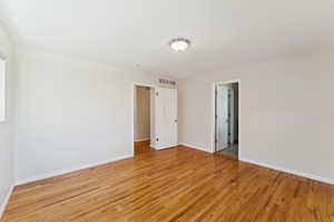 Unfurnished bedroom featuring light wood-style floors and baseboards
