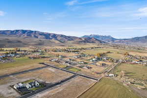 Aerial view of property and surrounding area featuring mountains and rural landscape