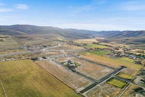 Aerial overview of property's location with a mountain backdrop and rural landscape