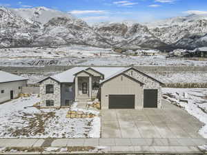 View of front of property with board and batten siding, stone siding, and a mountain view