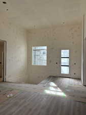 Unfurnished room featuring wood finished floors and wallpapered walls