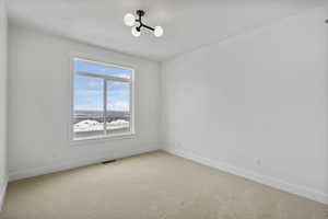 Empty room featuring light carpet and baseboards