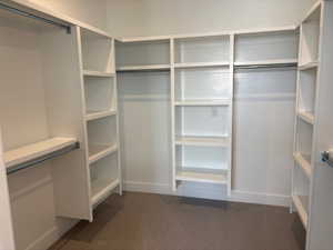 Walk in closet featuring dark carpet