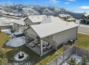 Enhanced photo (Landscaping not included) Snowy aerial view featuring a mountain view and a residential view
