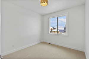Spare room with light colored carpet and baseboards