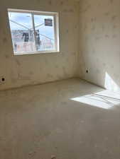 Spare room featuring carpet and wallpapered walls