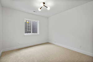 Spare room with light carpet and hanging lights