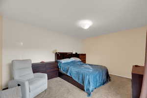 Bedroom featuring carpet floors and baseboards