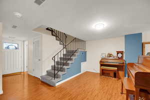 Foyer featuring light wood finished floors and stairs