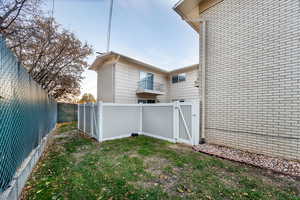 View of property exterior with a fenced backyard and brick siding