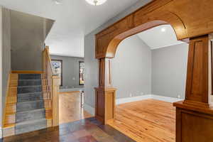 Interior space inside front entrance with custom wood arched walkways, wood flooring, and recessed lighting