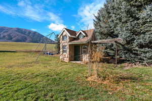 View of an included playhouse, a yard, a mountain view, and a view of rural / pastoral area