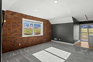 Additional view of large bedroom with brick accent wall, ensuite bathroom, exterior balcony with mountain and resort views