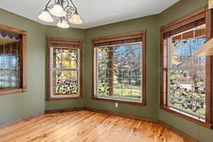 Unfurnished office  featuring wood floors, custom wood trim, interior/exterior windows