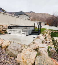 Fenced backyard featuring a patio area and a mountain view