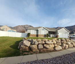 View of front of house featuring stone siding, a mountain view, stucco siding, and a porch