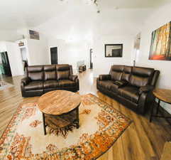 Living area featuring vaulted ceiling and light wood-style flooring