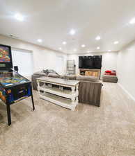 Living area with light colored carpet and recessed lighting