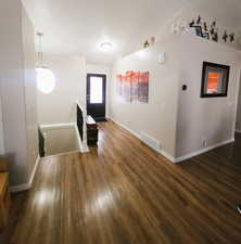 Foyer entrance featuring dark wood finished floors and baseboards