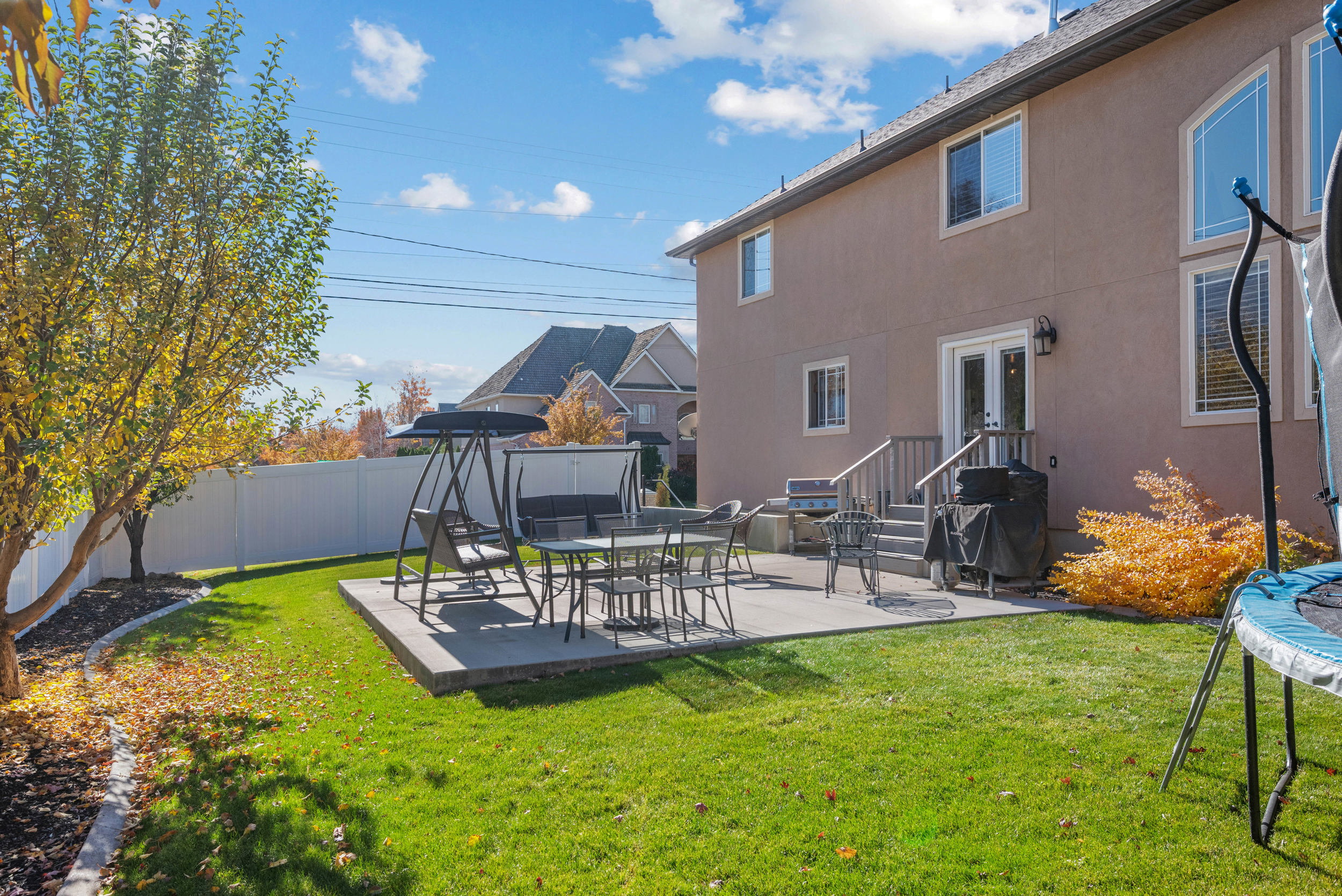 Fenced backyard featuring a patio and a trampoline