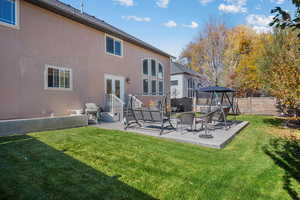 Back of house with a patio area, stucco siding, a fenced backyard, a trampoline, and french doors