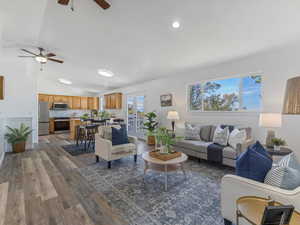 Living area with lofted ceiling, dark wood-type flooring, a ceiling fan, and french doors
