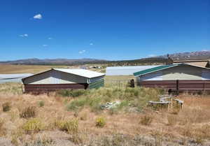 View of yard featuring a mountain view, a pole building, and an outdoor structure