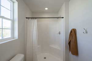 Bathroom with a stall shower and toilet
