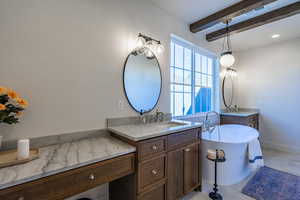 Full bathroom with a soaking tub, two vanities, beamed ceiling, light tile patterned floors, and recessed lighting