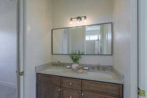 Full bathroom featuring double vanity and a shower with shower curtain