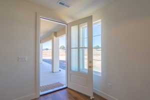Doorway with wood finished floors and plenty of natural light