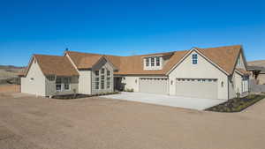 Traditional home featuring driveway, roof with shingles, a garage, and stucco siding