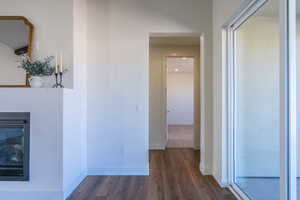 Corridor featuring baseboards and dark wood-type flooring
